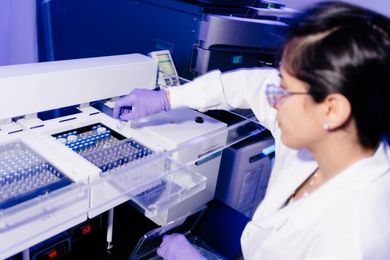 Scientifique qui porte des lunettes de sécurité, une tenue de laboratoire et des gants