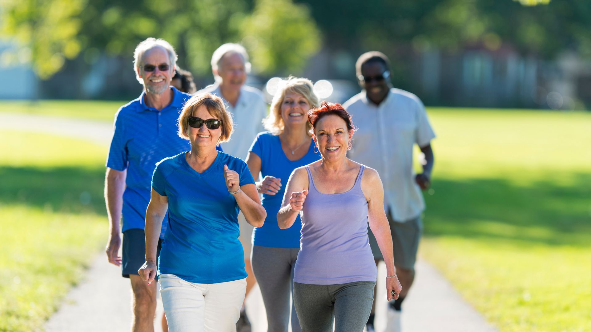 Grupo de adultos mayores caminando en un parque