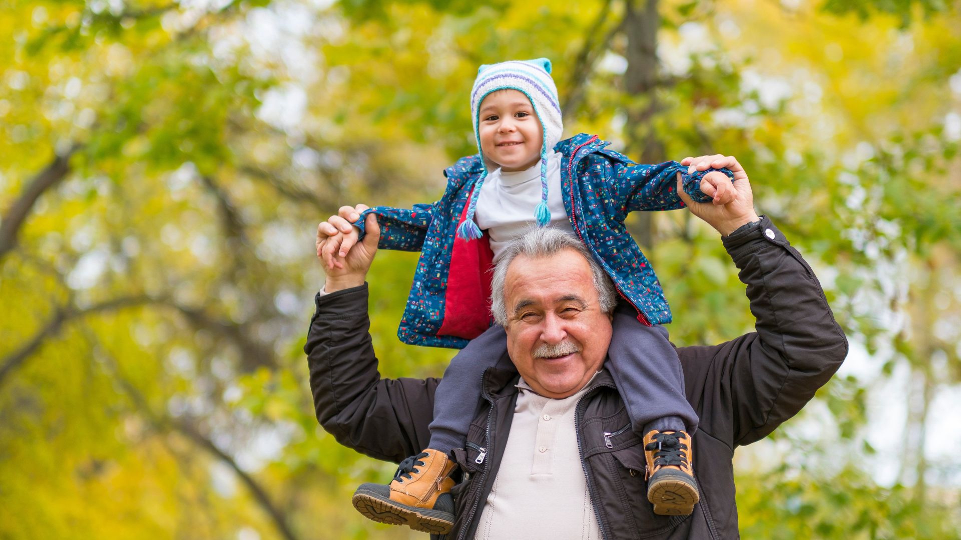 Abuelo cargando en hombros a su nieto