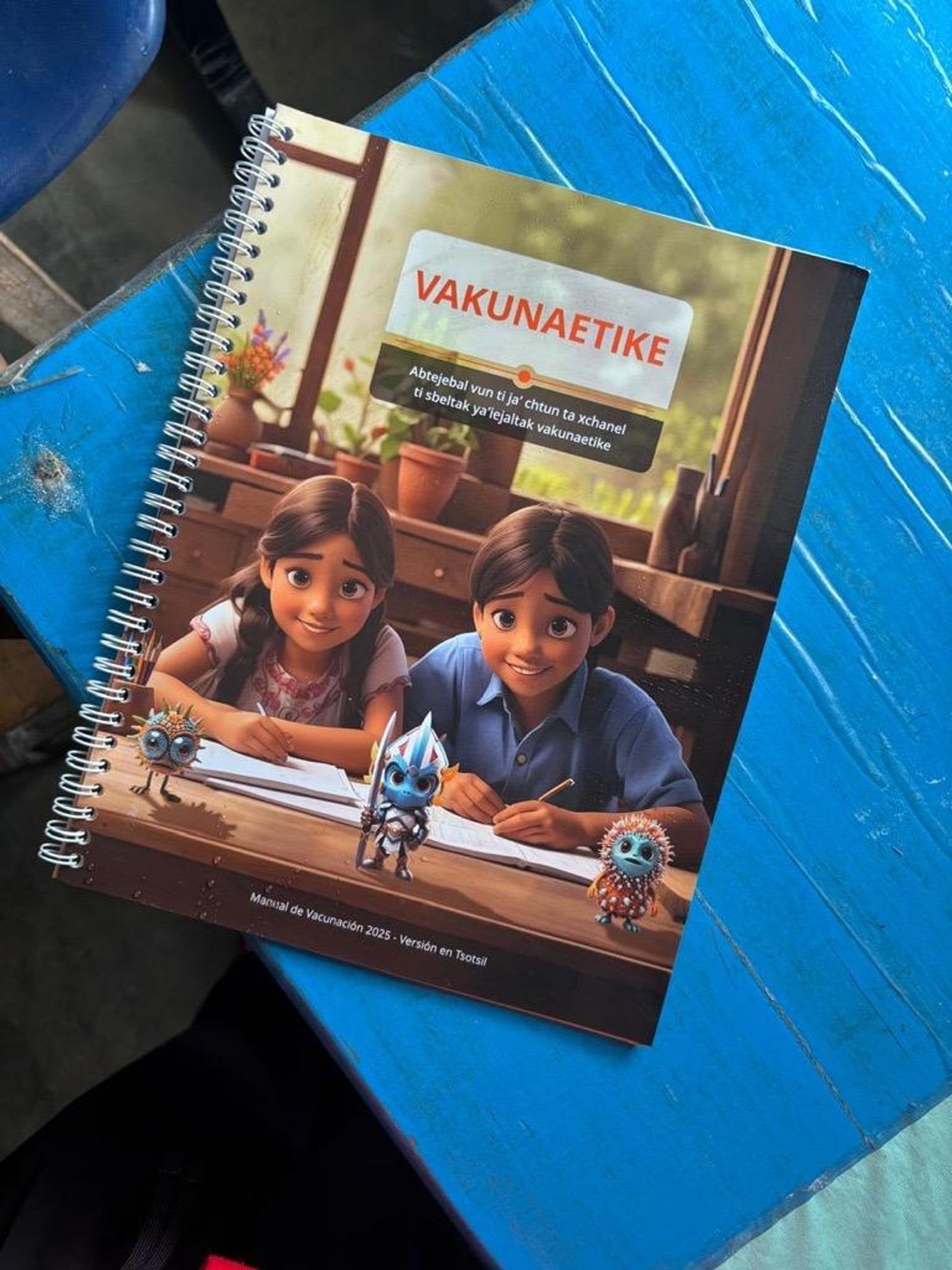 Manual de vacunación traducido a una lengua indígena sobre una mesa