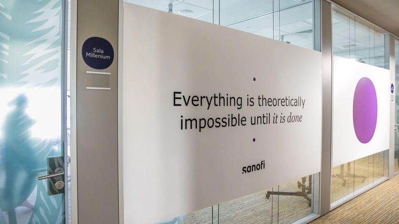 Perete de sticlă din birourile Sanofi Romania pe care se află textul: Everything is theoretically impossible until it is done.