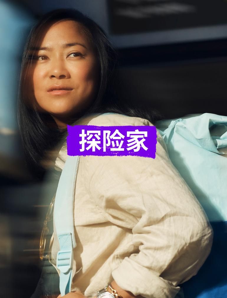 位穿着黄色衬衫、背着蓝色背包的女士，带着梦幻般的表情凝视远方。 叠加文字显示：“探险家”​