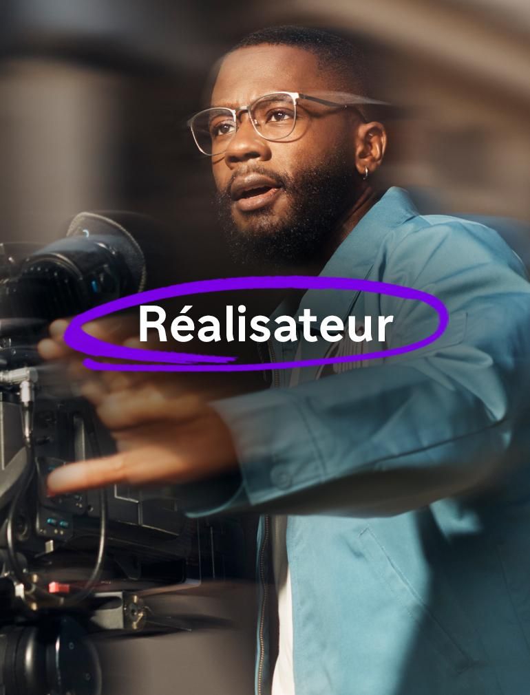 Un homme portant des lunettes et une veste bleue utilise une caméra vidéo et paraît concentré pendant qu’il filme, sa main est tendue devant lui tandis qu’il fait un geste. Le texte en surimpression indique : « Réalisateur. »​
