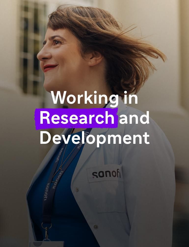 A smiling woman wearing a white Sanofi lab coat and company badge smiles while walking forward outside of a building. Several people are running alongside her in the background, they are blurred in motion. Overlay text reads: "Working in Research and Development."​
