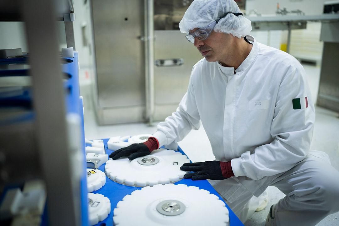 Installation de production de vaccins avec équipements industriels et personnel en tenue de protection