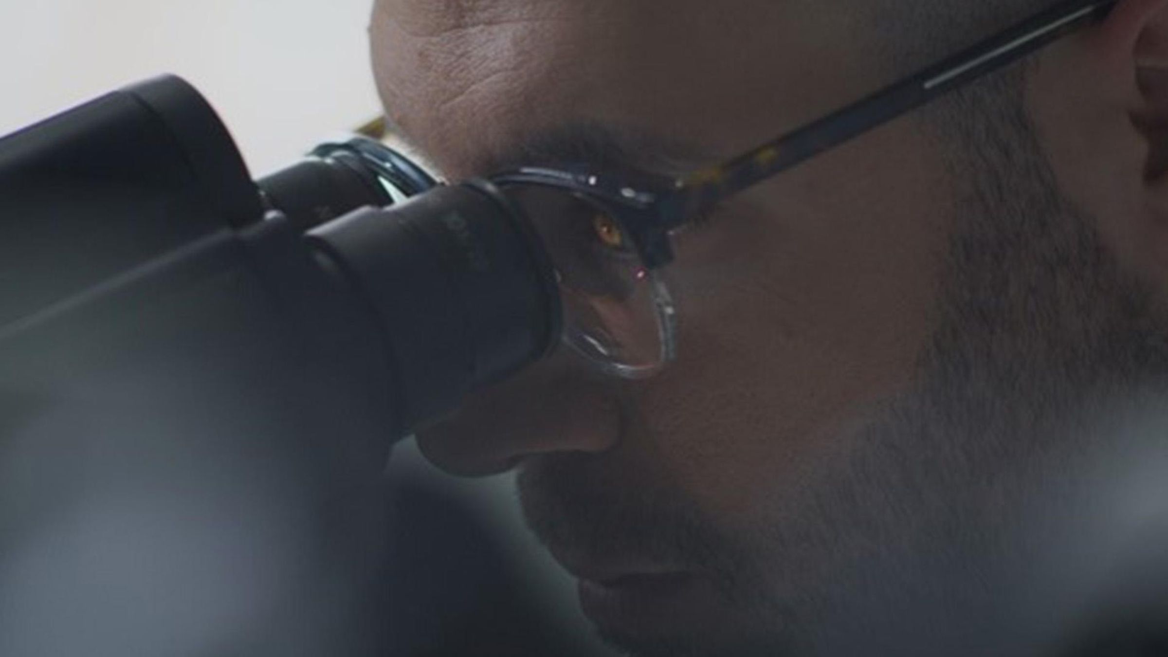 Image of scientist looking in a microscope