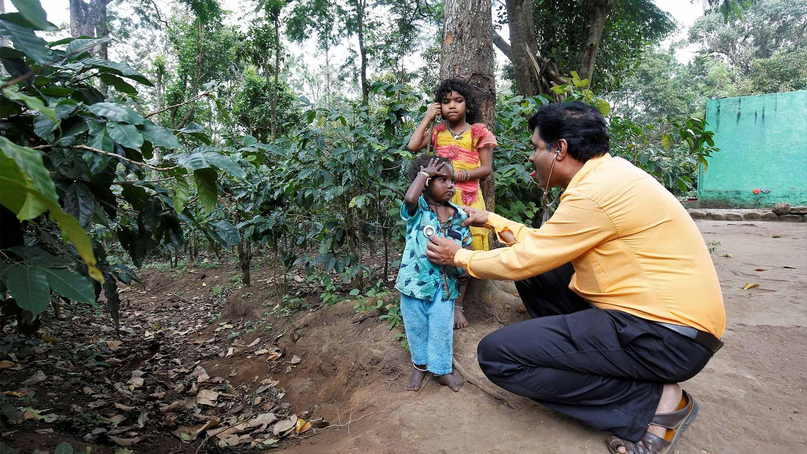 Dr. Lingaraju checks the health of Manikantan as his sister Geetha watches closely inside the Billigiri Ranganathaswamy Temple Tiger Reserve in Chamrajanagara district, Karnataka state, India