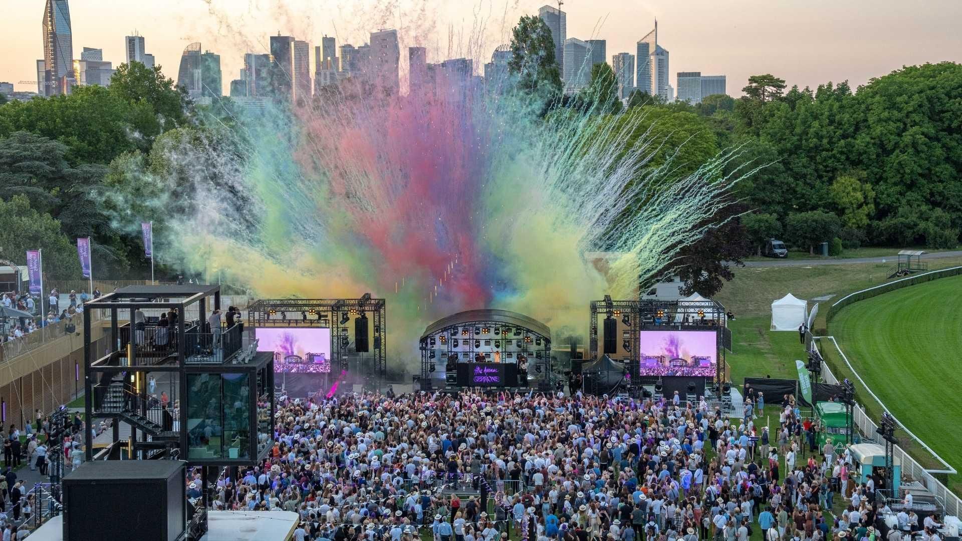 Aerial view of outdoor concert at Sanofians Summer Festival 2025 with large crowd, colorful confetti, and city skyline backdrop