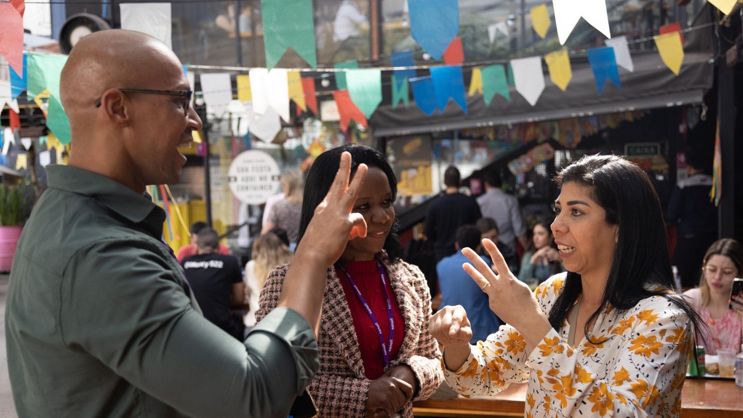 3 Sanofians in Brazil, talking in sign language