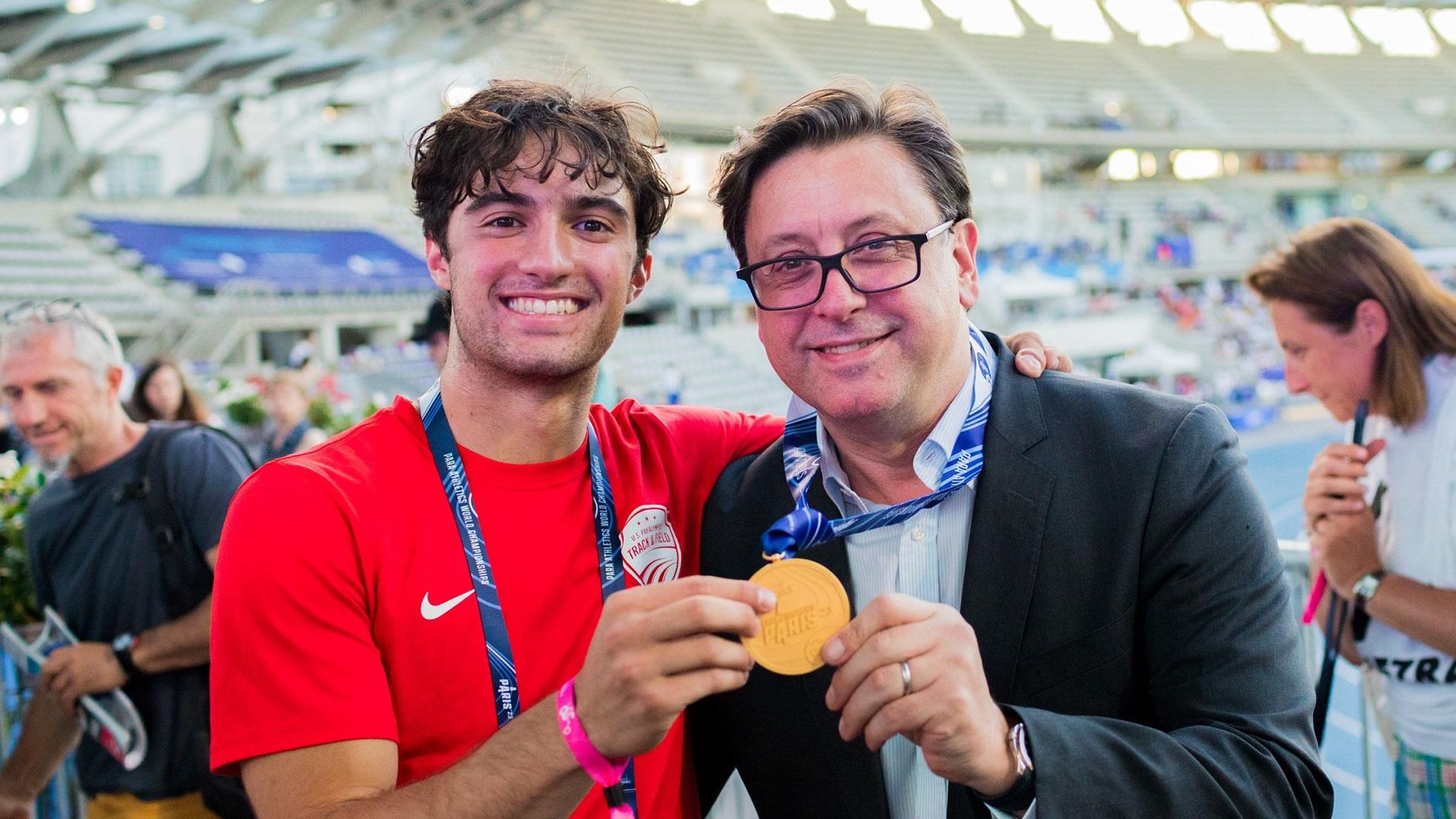 Paul Hudson, PDG de Sanofi, et Ezra Frech, athlète américain membre de la Team Sanofi, fêtent la médaille d'or d'Ezra aux championnats du monde de para-athlétisme à Paris, en juillet 2023.